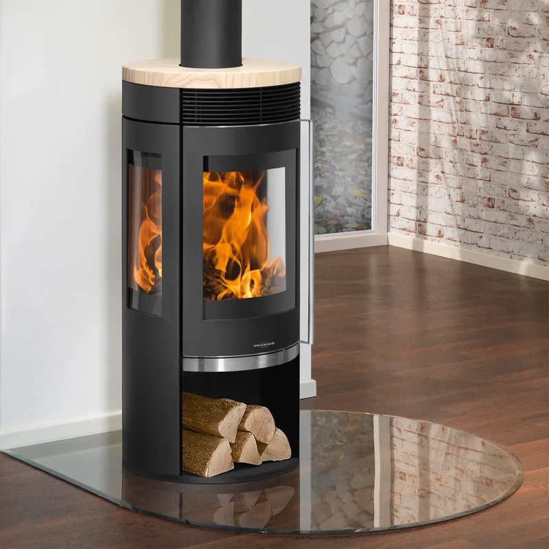 Poêle à bois Oranier Rota TRE 2.0 en acier noir avec plaque de recouvrement en pierre de sable.